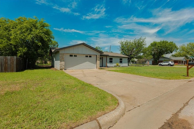 1017 SE 21st St, Mineral Wells, TX 76067 - ranch-style house with board and batten siding, driveway, a front yard, a garage, and fence