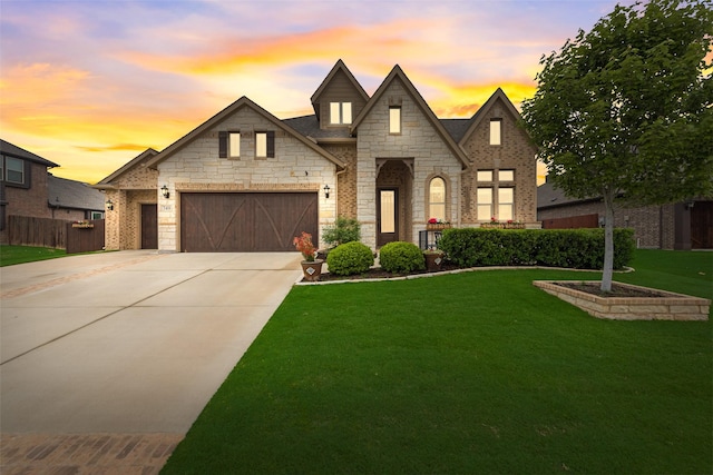 french provincial home with driveway, a garage, and stone siding