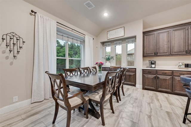 dining room featuring vaulted ceiling and baseboards