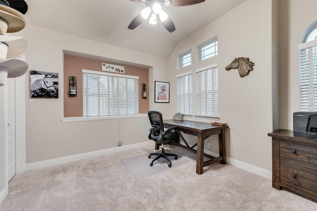 carpeted home office with a ceiling fan, vaulted ceiling, and baseboards