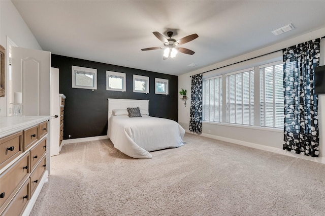 bedroom featuring baseboards, light colored carpet, and a ceiling fan