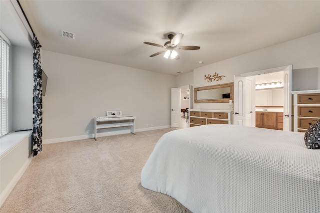 carpeted bedroom featuring baseboards, a ceiling fan, and ensuite bath