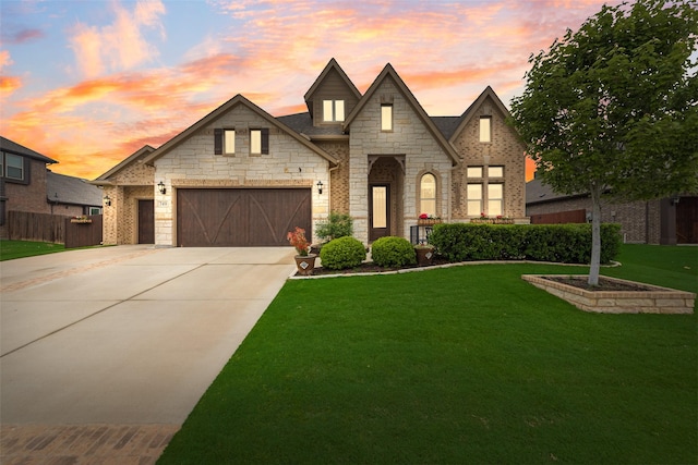 french country home with driveway, stone siding, and a garage