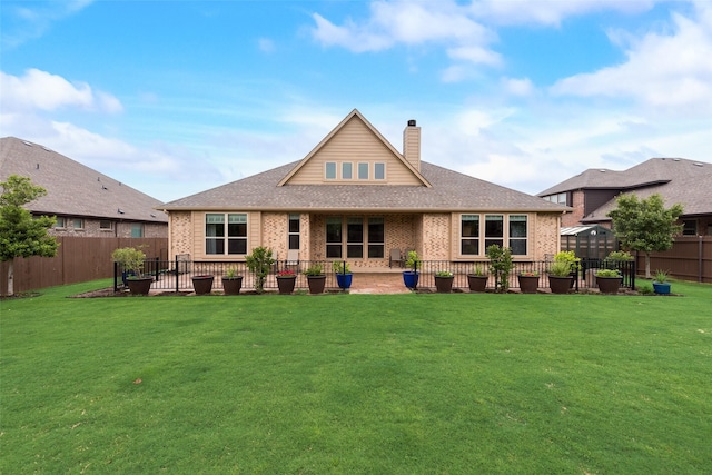 back of property featuring brick siding, a chimney, a patio area, and a shingled roof