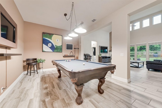 recreation room featuring billiards, baseboards, healthy amount of natural light, light wood finished floors, and a high ceiling