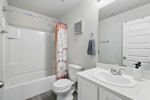 bathroom with visible vents, vanity, shower / bath combo with shower curtain, wood finished floors, and toilet