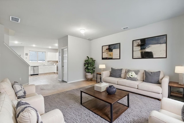 living room with recessed lighting, baseboards, light wood-type flooring, and visible vents