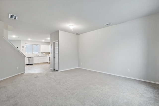 unfurnished living room with visible vents, baseboards, and light colored carpet