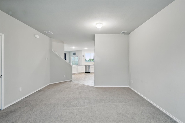 unfurnished room with light colored carpet and baseboards