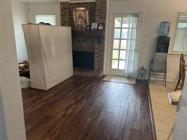 living area featuring a brick fireplace and wood finished floors