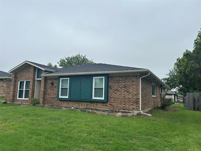 view of side of property with a lawn and brick siding
