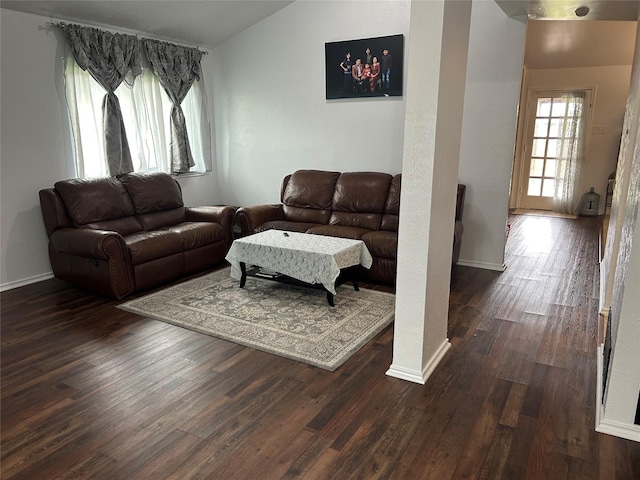 living room featuring baseboards and dark wood-type flooring