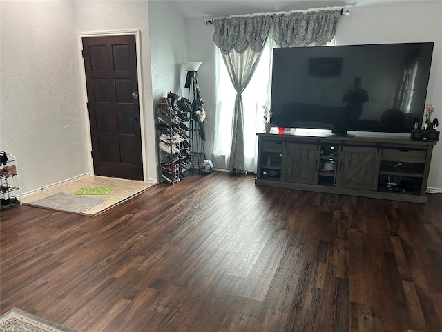 living room with baseboards, a textured wall, and wood finished floors