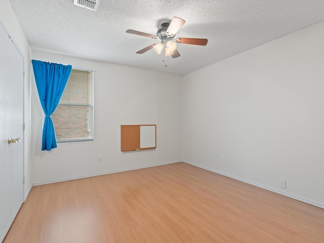 1728 Creek Bend Ln, Little Elm, TX 75068 - unfurnished room with visible vents, baseboards, light wood-type flooring, a textured ceiling, and a ceiling fan