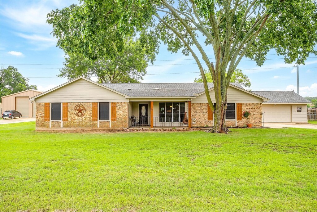 132 Southwood Dr, Burleson, TX 76028 - ranch-style home featuring brick siding, a front lawn, driveway, and a detached garage