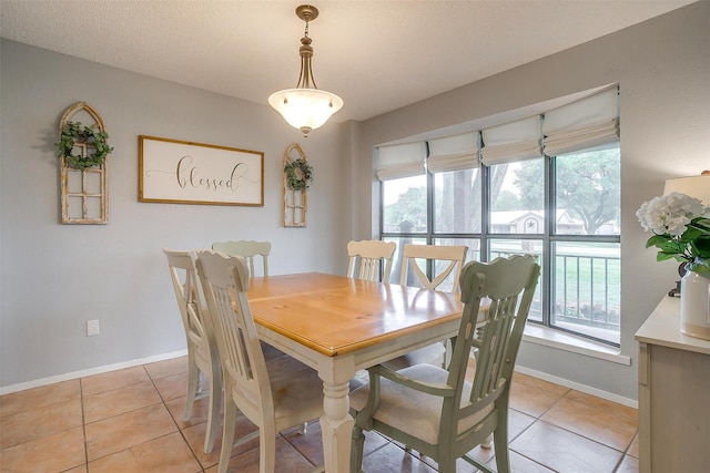 dining space featuring a healthy amount of sunlight, baseboards, and light tile patterned flooring