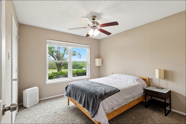 carpeted bedroom featuring baseboards, ceiling fan, and a textured ceiling