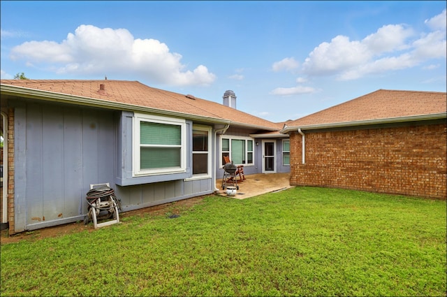 rear view of house featuring a patio area and a yard