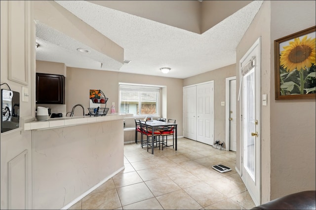 entrance foyer with a textured ceiling and light tile patterned floors