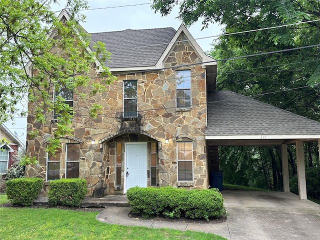 view of front of home featuring a shingled roof, a carport, stone siding, and concrete driveway