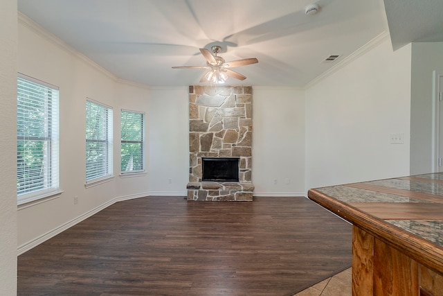 315 Lakeside Dr, Rockwall, TX 75032 - unfurnished living room featuring healthy amount of natural light, ceiling fan, ornamental molding, wood finished floors, and a stone fireplace