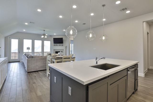 kitchen featuring a ceiling fan, visible vents, stainless steel dishwasher, a sink, and light wood-style flooring