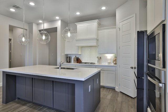 kitchen with a sink, appliances with stainless steel finishes, dark wood-style flooring, and visible vents
