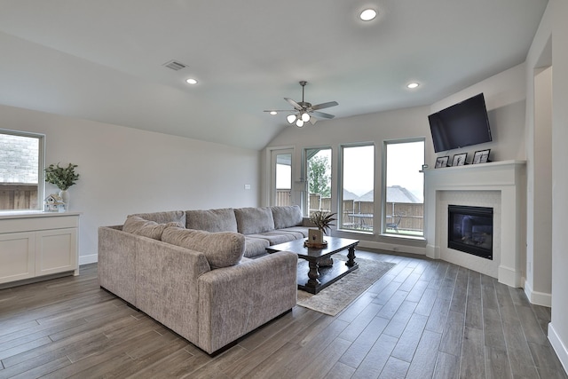 living room featuring baseboards, ceiling fan, visible vents, and wood finished floors