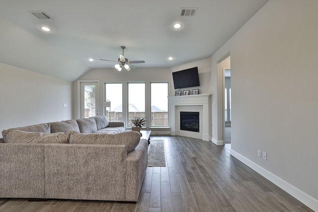 living room with a ceiling fan, visible vents, and dark wood-style floors