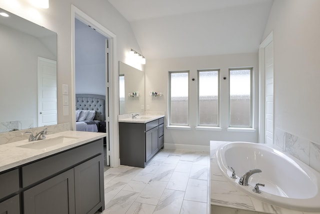 full bath with a sink, ensuite bathroom, vaulted ceiling, and a garden tub
