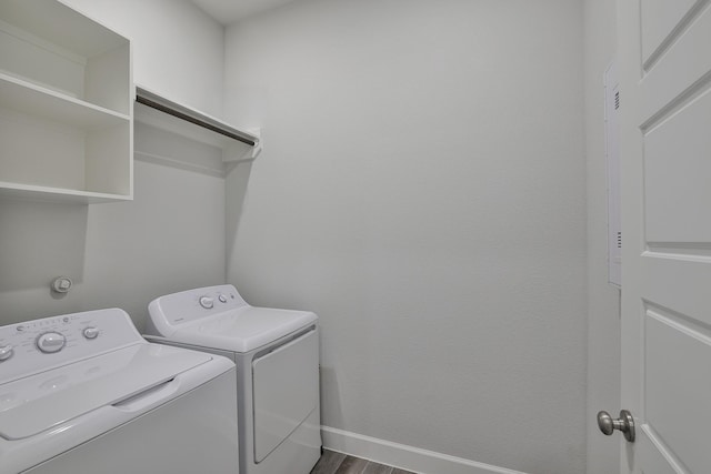 washroom featuring separate washer and dryer, baseboards, laundry area, and dark wood-style floors