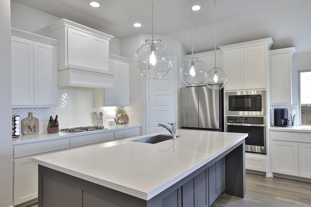kitchen with a sink, decorative backsplash, appliances with stainless steel finishes, and light countertops