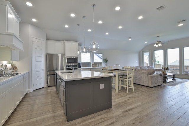 kitchen featuring light countertops, stainless steel appliances, visible vents, and vaulted ceiling