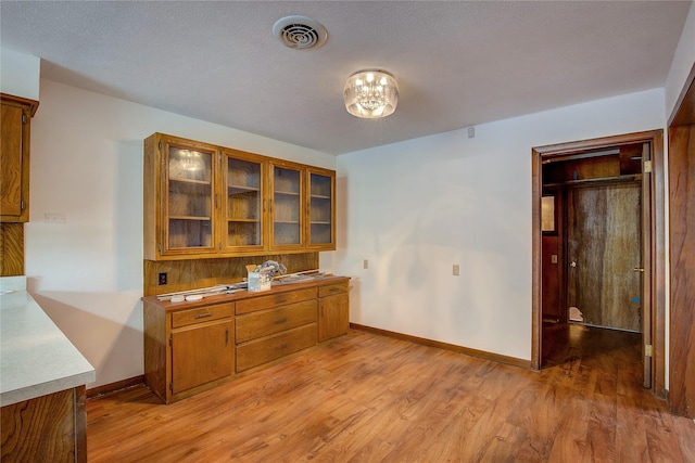 dining room with visible vents, light wood finished floors, and baseboards
