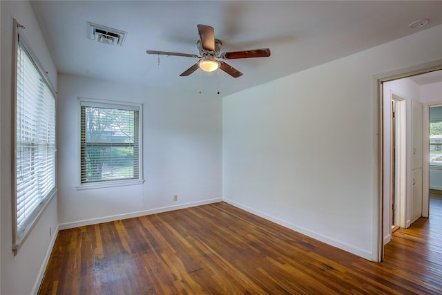unfurnished room featuring a healthy amount of sunlight, a ceiling fan, hardwood / wood-style flooring, and visible vents