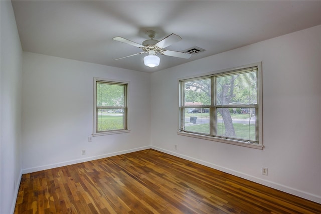 empty room with baseboards, a healthy amount of sunlight, and wood finished floors