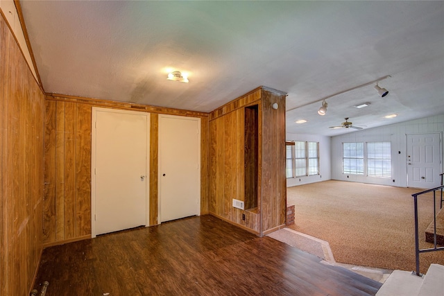 spare room with ceiling fan, visible vents, wood finished floors, track lighting, and wooden walls