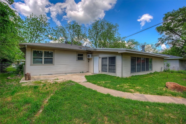 rear view of house with a lawn and fence