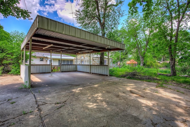 view of parking featuring concrete driveway and a carport