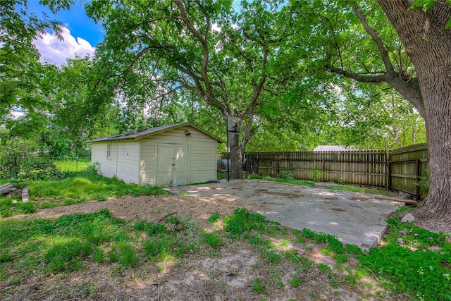 view of yard featuring an outbuilding, fence, and a storage shed