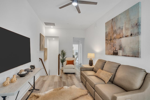 living area with light wood-style floors, a ceiling fan, and visible vents