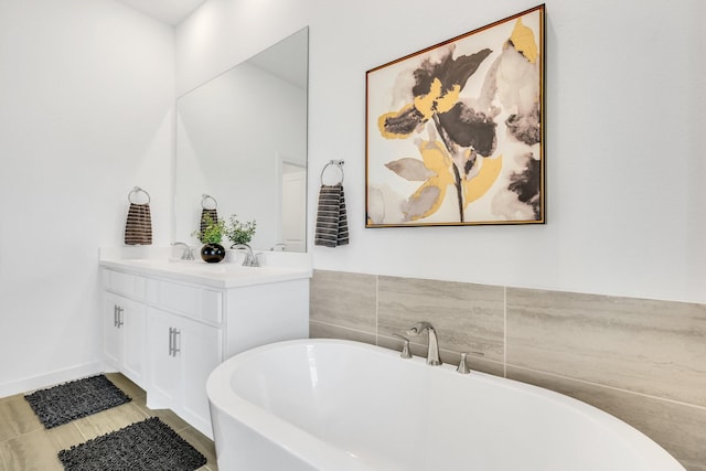 full bath featuring double vanity, a sink, and a soaking tub