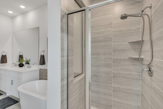 bathroom featuring vanity, recessed lighting, a soaking tub, and a stall shower