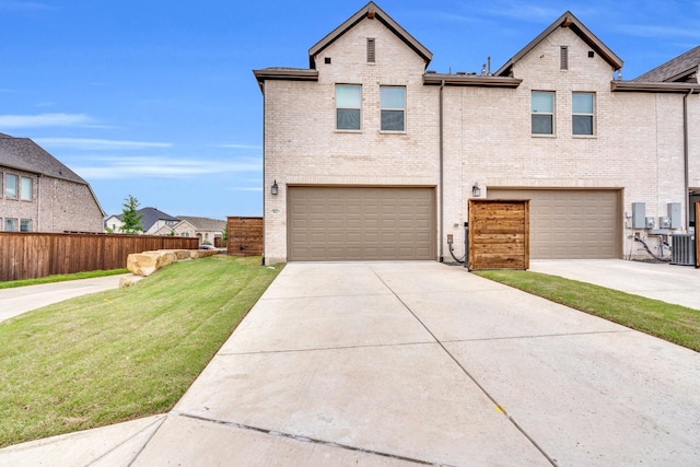multi unit property featuring an attached garage, brick siding, a front yard, central air condition unit, and driveway
