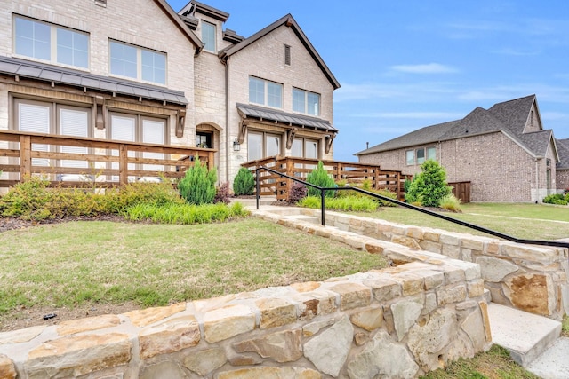 rear view of property with fence, a lawn, and brick siding
