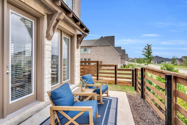 view of patio featuring a residential view and fence