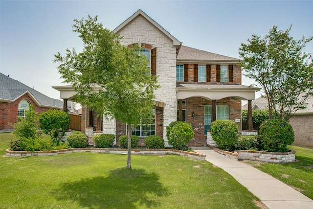 2501 Del Largo Way, Frisco, TX 75033 - view of front of house with brick siding, a front lawn, covered porch, and stone siding