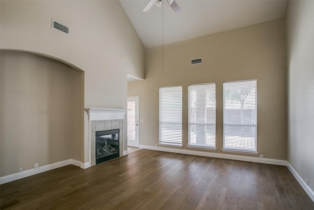 2501 Del Largo Way, Frisco, TX 75033 - unfurnished living room with visible vents, ceiling fan, high vaulted ceiling, dark wood-type flooring, and a tiled fireplace