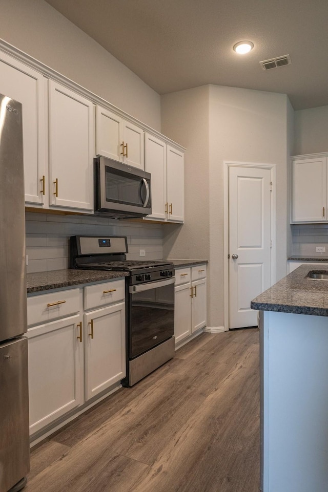 6000 Sutton Fields Trl, Celina, TX 76227 - kitchen featuring visible vents, dark wood-style flooring, white cabinetry, tasteful backsplash, and appliances with stainless steel finishes