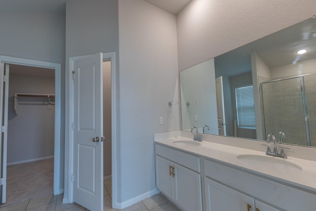 6000 Sutton Fields Trl, Celina, TX 76227 - bathroom with tile patterned flooring, a sink, a spacious closet, and a shower stall